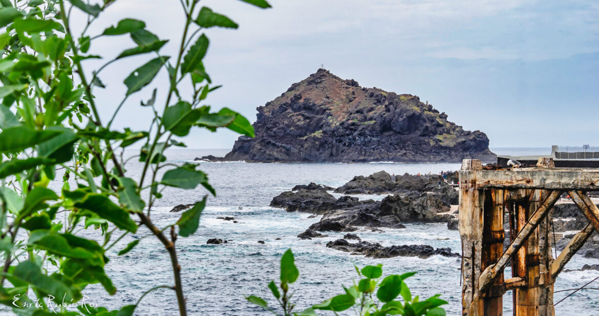Looking through trees towards a craggy rock in Garachico, Tenerife