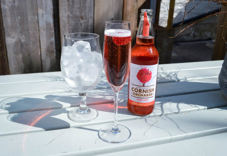 Two drinks sat on a sunny table in the outdoor garden bar