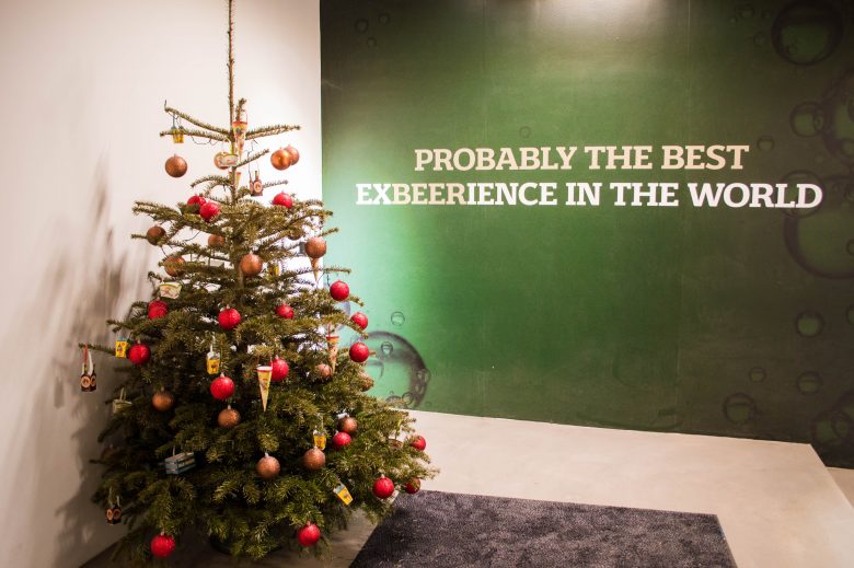 A Christmas tree next to a sign that says "Probably the best experience in the world" at Carlsberg, Copenhagen