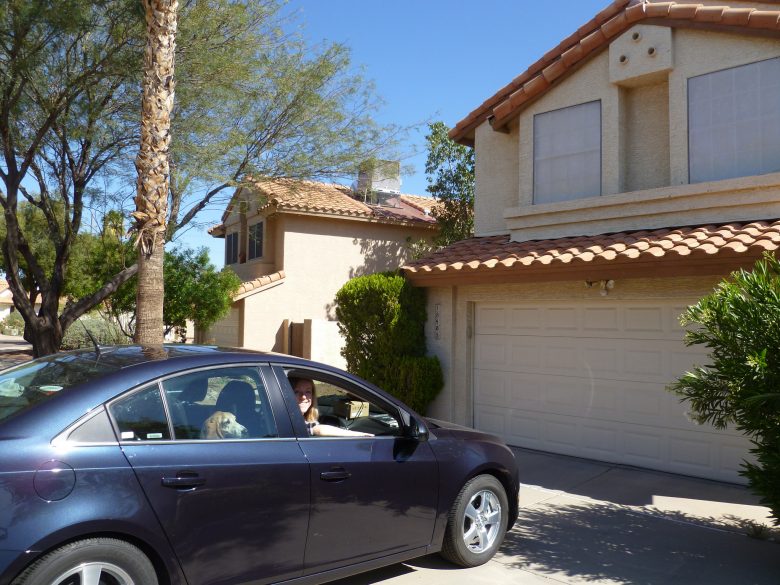 Black car parked in driveway in front of house