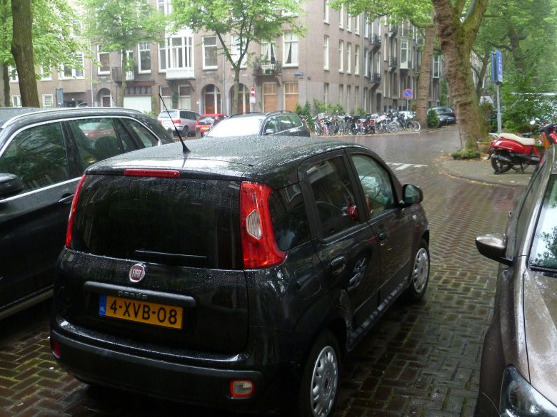 Black car parked on a rainy street