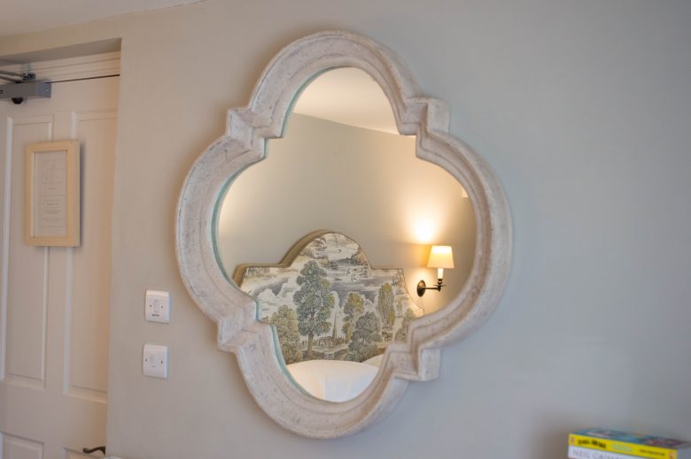A decorative mirror on the wall in our bedroom