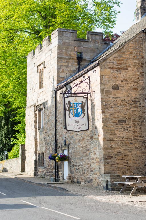 The historic exterior and hanging sign outside of The Lord Crewe Arms