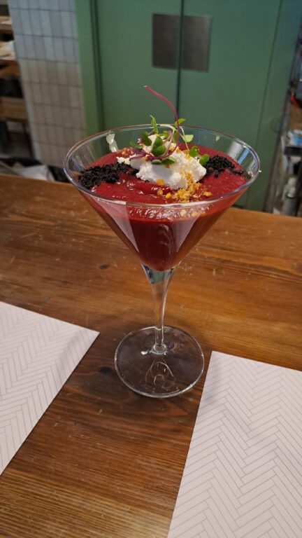 Cocktail glass filled with beet salmorejo at la brunilda