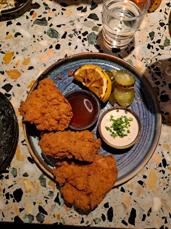 A plate of fried chicken and dipping sauces