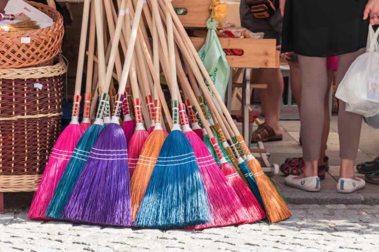 Selection of colourful brooms being sold at a market