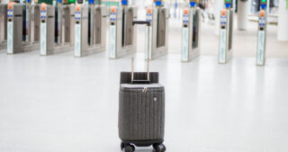 Suitcase sitting in front of the automatic gates at a train station