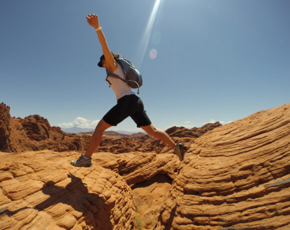 woman jumps across rocks