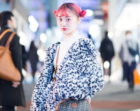 woman with bright pink hai and funky jacket on busy shopping street