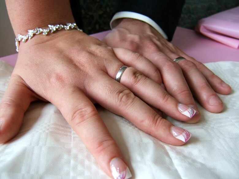 Wedding rings on fingers on table