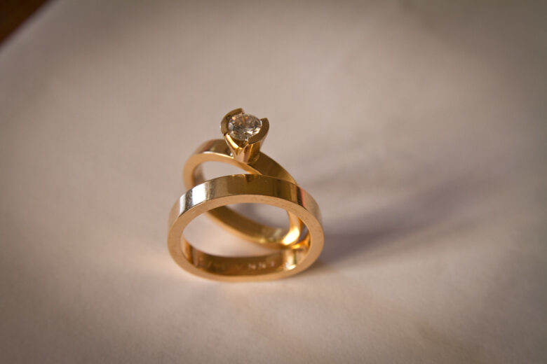 two gold wedding rings on a table