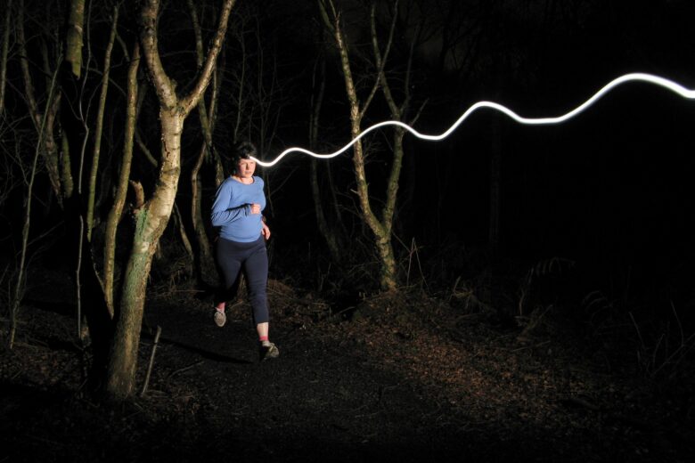 Runner in the woods at night with a heatorch