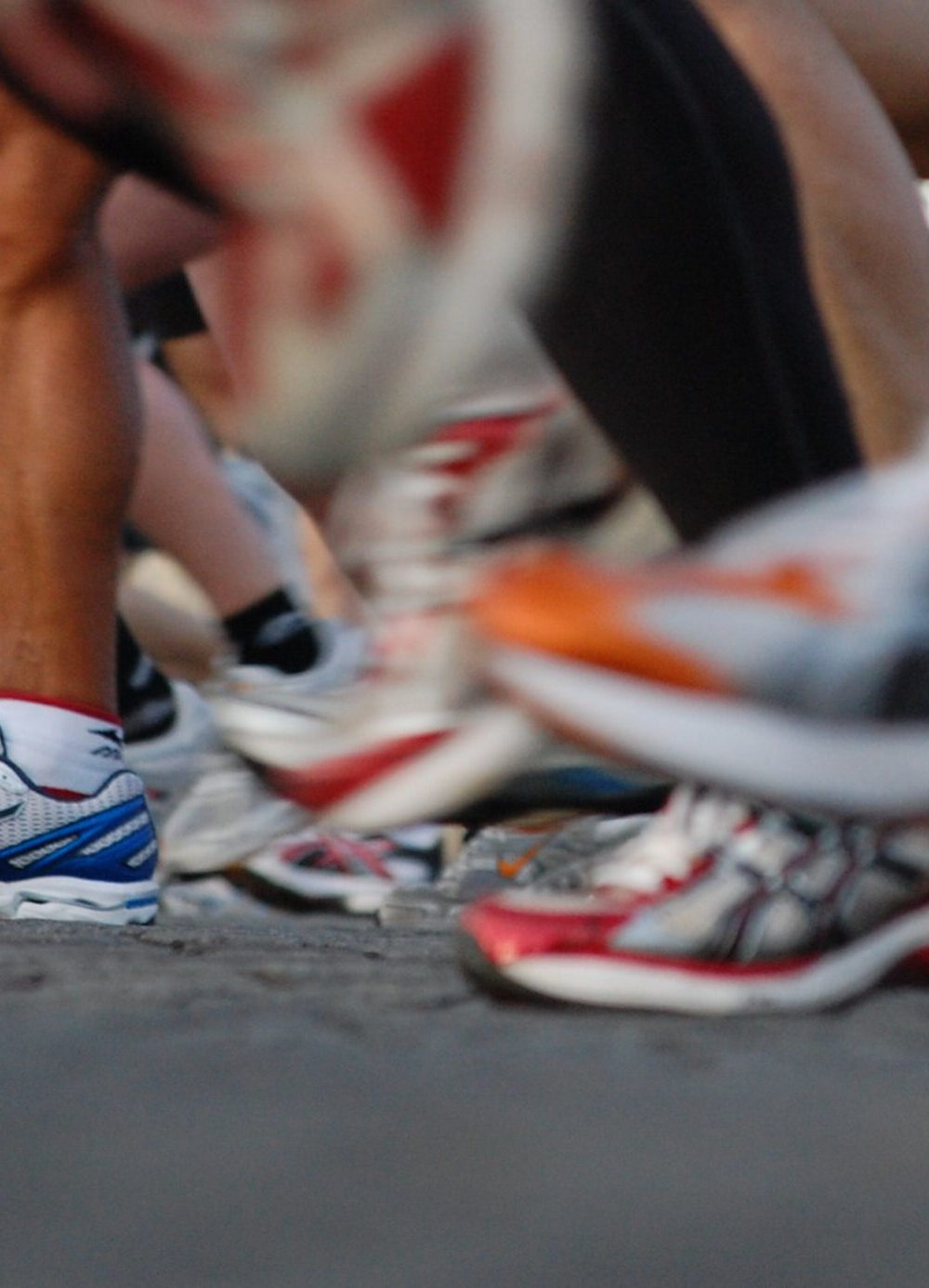 running shoes on the feet of several runners in an organized race.