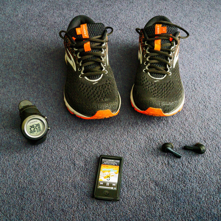 running gear featuring shoes, smart watch, earbuds and tracker.