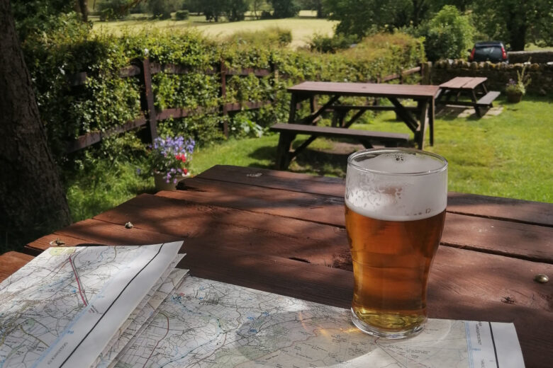 A pint of beer on a pub table with an OS map