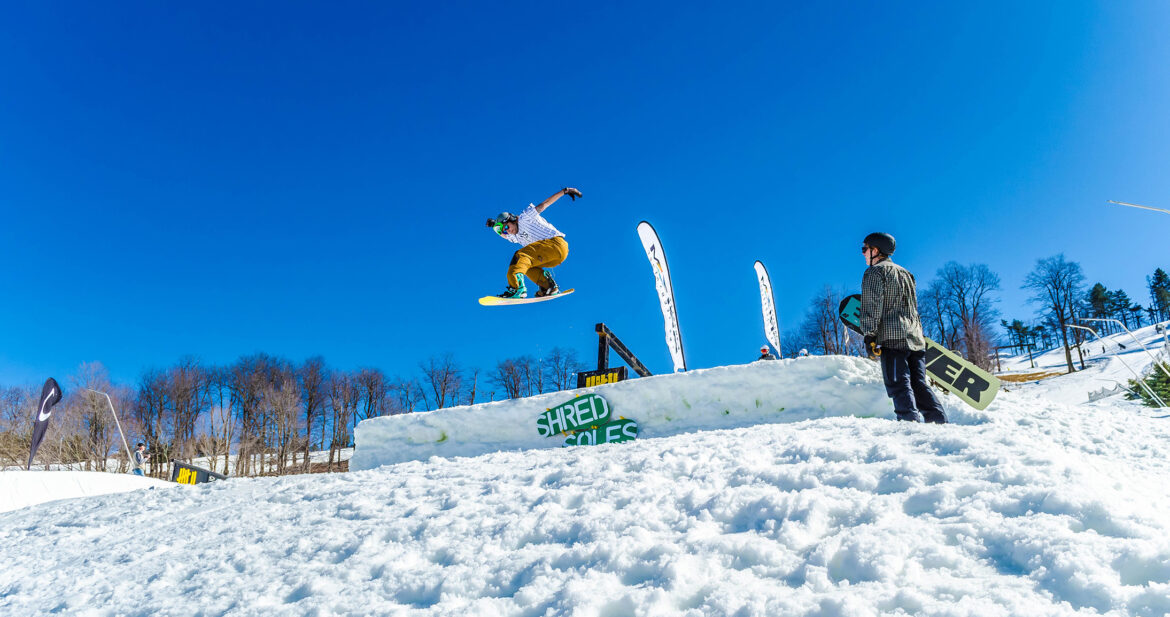 Snowboarder jumping over a ramp on a ski slope