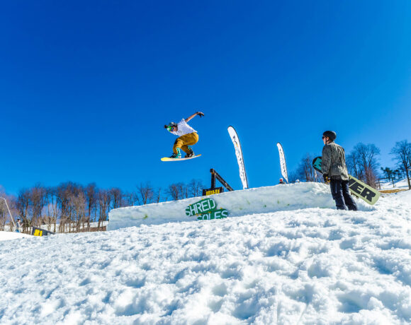 Snowboarder jumping over a ramp on a ski slope