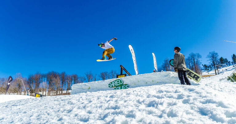 Snowboarder jumping over a ramp on a ski slope
