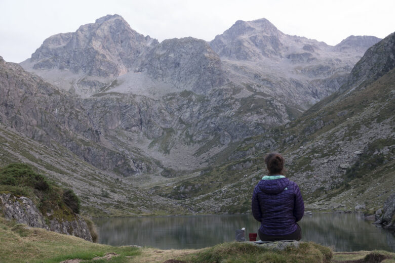 Women sitting alone looking at a mountain landscape after a hike
