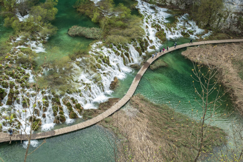 Overhead view of a walkway next to a large waterfall in the middle of Plitvice National Park, Croatia,