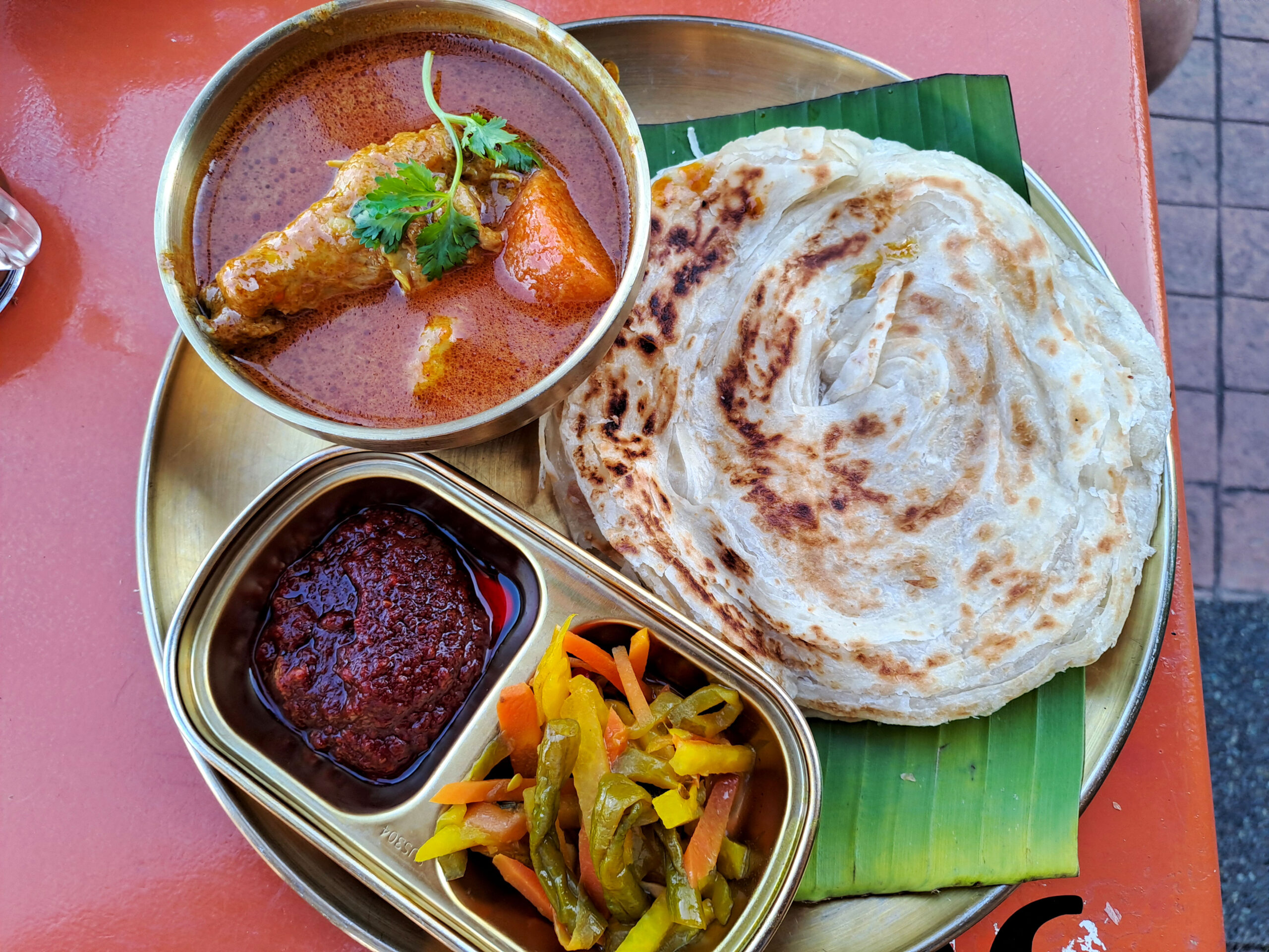 Roti canai with chicken curry, peppers and sambal at Baba Kaya